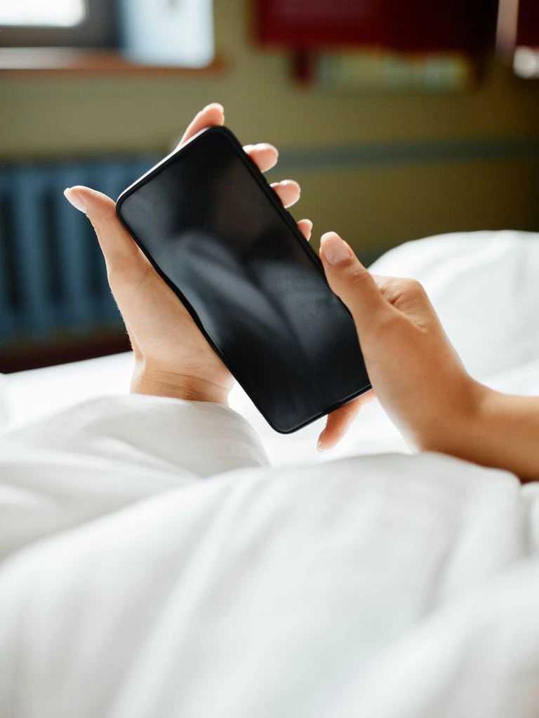 A phone resting on linen, showing a treasury app with charts.