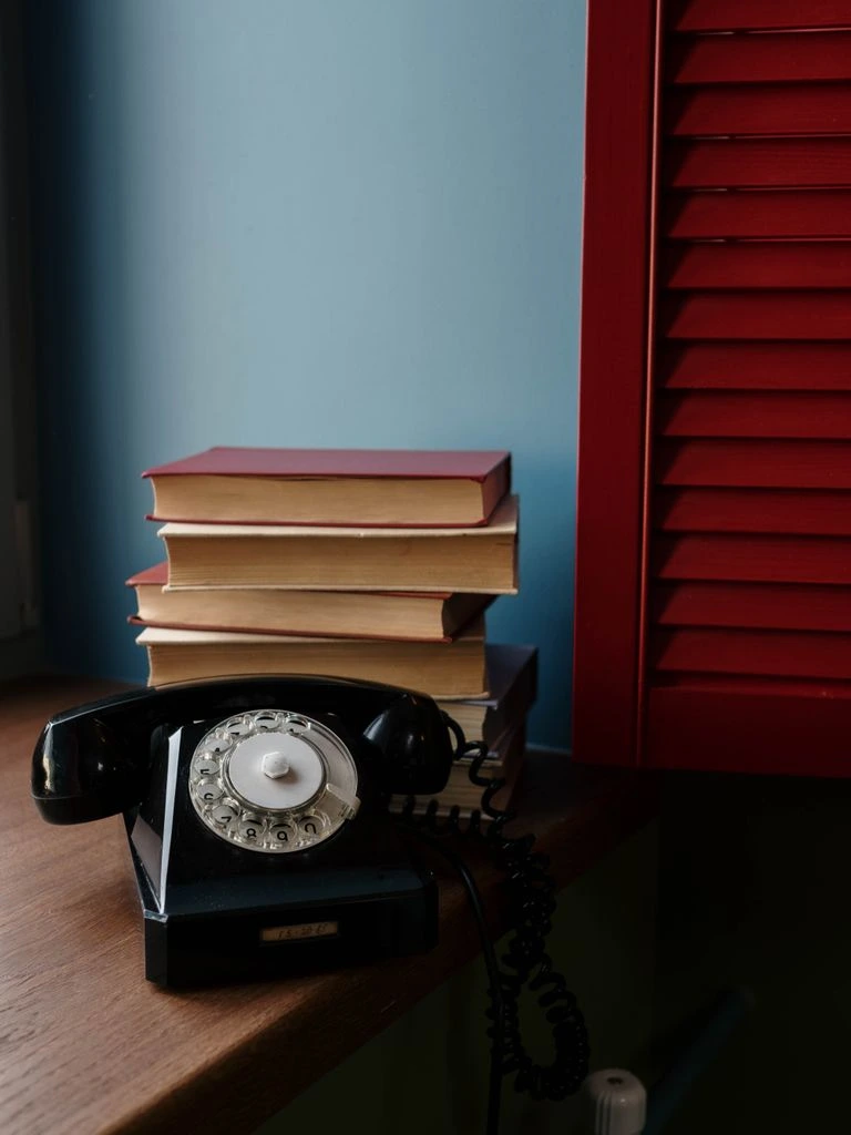 A phone leaning against stacked books, showing a reading app.