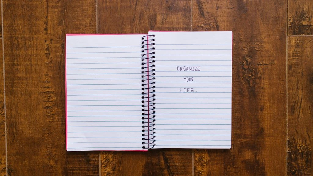 A notebook and laptop on a desk showing a developer landing page.